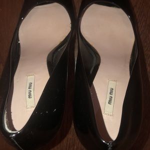 Black Miu Miu high heeled shoes.